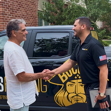 A Buccos Roofing team member speaking with a homeowner