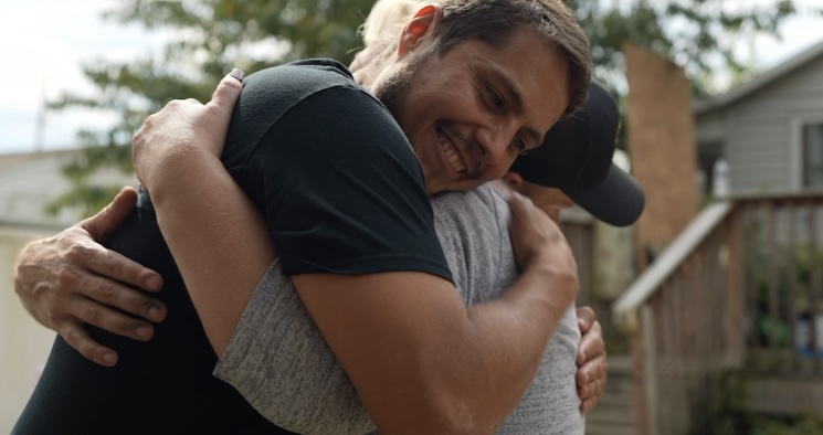 Buccos Roofing team member hugging a previous giveaway recipient.